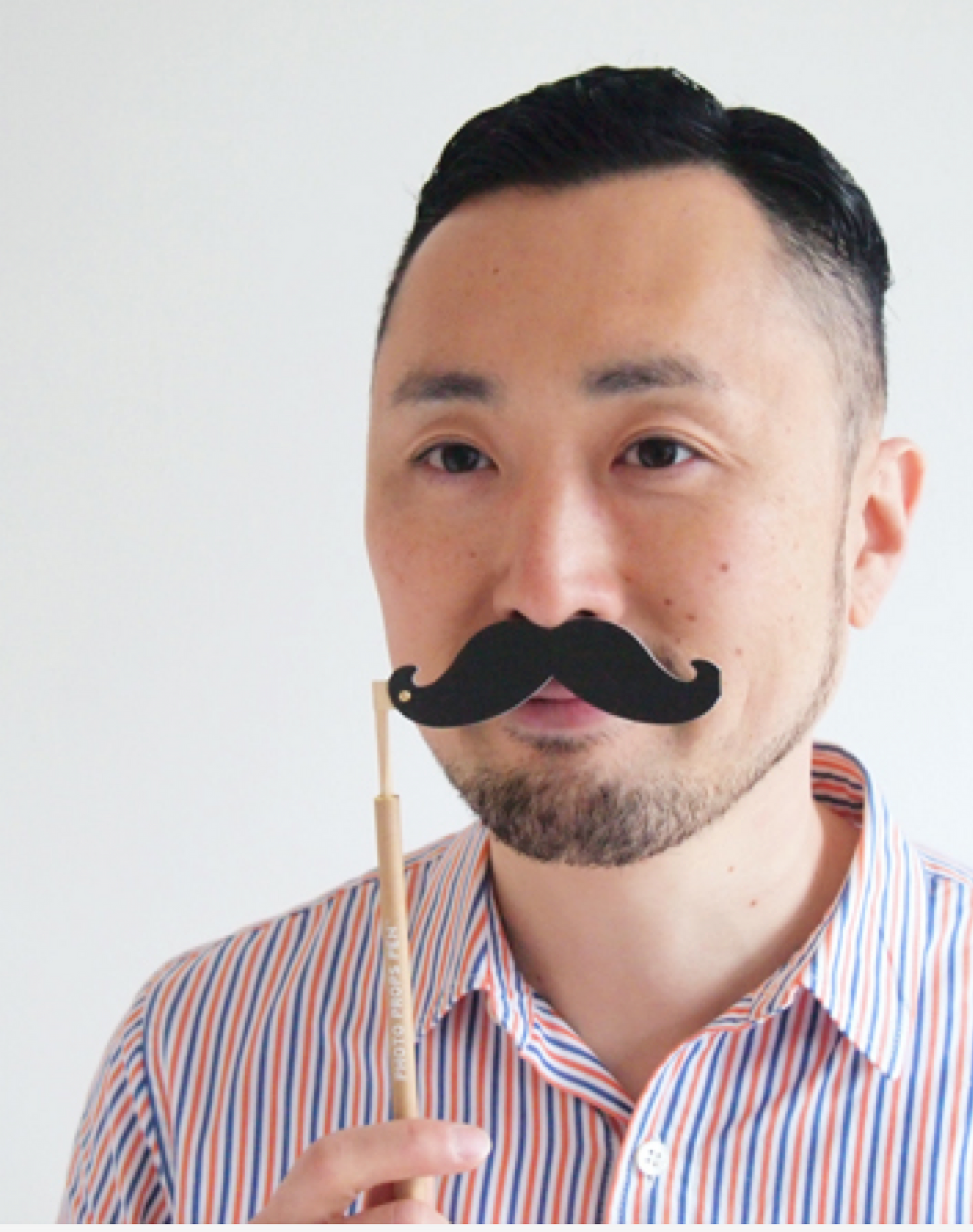 A man is trying a mustache photo props pen
